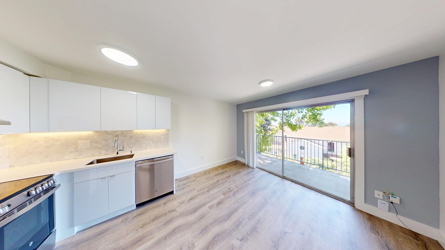 A kitchen with white cabinets and a wooden countertop.